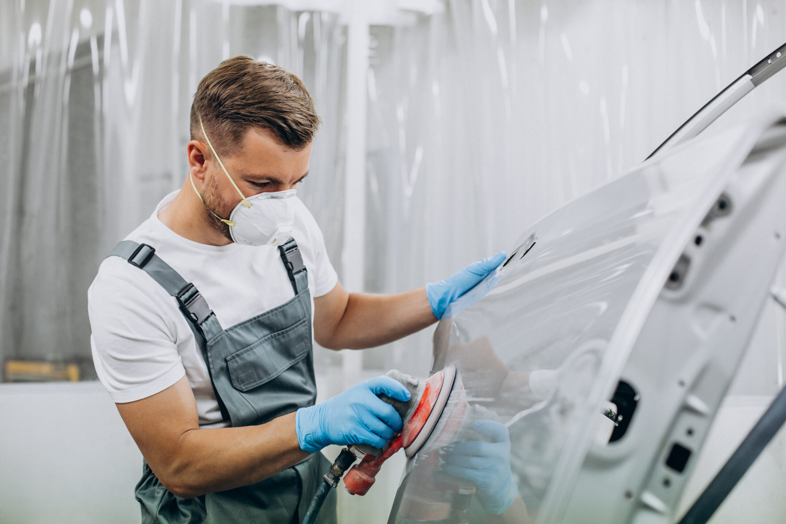 Car mechanic polishing car before painting Karosseriebauer